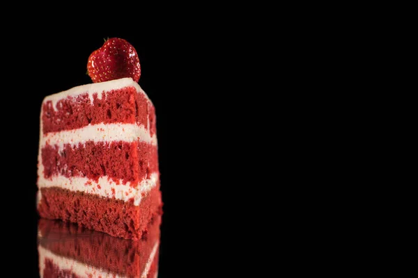 Peace of white and red cream cake with strawberry isolated on black — Stock Photo