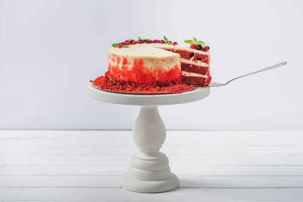 Gâteau blanc décoré de feuilles de cassis et de menthe sur pied isolé sur blanc — Photo de stock