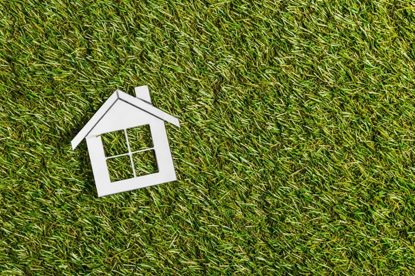 Вид на белый бумажный дом на зеленой траве, энергоэффективность в домашних условиях — стоковое фото