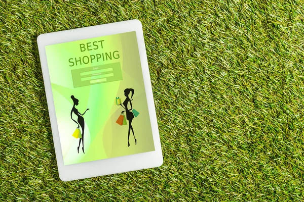 Ansicht des digitalen Tablets mit Shopping-App auf dem Bildschirm auf grünem Gras, Energieeffizienzkonzept — Stockfoto