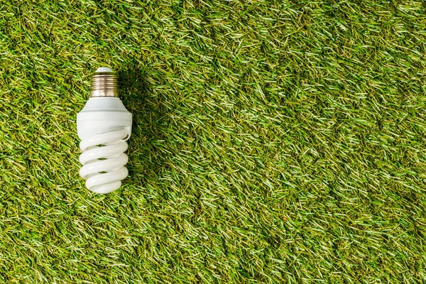 Top view of fluorescent lamp on green grass, energy efficiency concept — Stock Photo