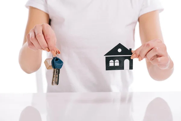 Vue partielle de la femme tenant la maison en papier et les clés isolées sur blanc, concept hypothécaire — Photo de stock