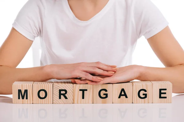 Cropped view of woman with hands on wooden cubes with mortgage lettering isolated on white — Stock Photo