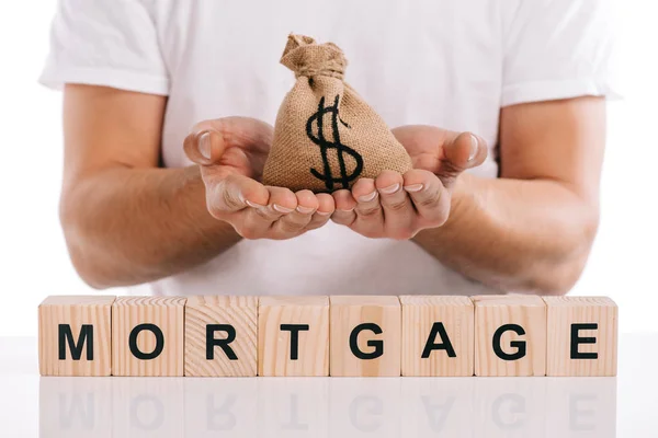 Cropped view of man holding moneybag near cubes with mortgage lettering isolated on white — Stock Photo