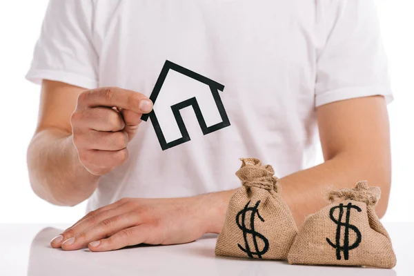 Cropped view of man holding paper house near moneybags isolated on white, mortgage concept — Stock Photo