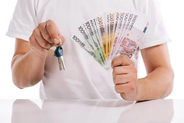 Abgeschnittene Ansicht eines Mannes mit Bargeld und Schlüsseln, isoliert auf weißem, Hypothekenkonzept — Stockfoto