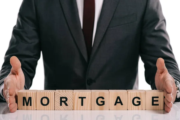 Cropped view of businessman holding wooden cubes with mortgage lettering isolated on white — Stock Photo