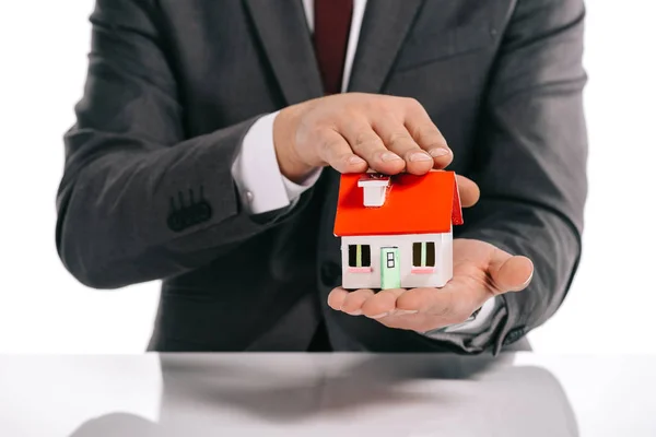 Partial view of mortgage broker holding house model isolated on white — Stock Photo