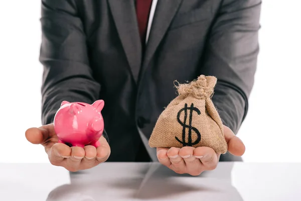 Vista ritagliata del mediatore ipotecario che tiene salvadanaio e moneybag isolato su bianco — Foto stock