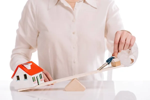 Cropped view of businesswoman weighing house model and keys isolated on white, mortgage concept — Stock Photo