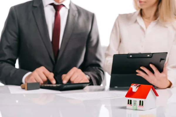 Enfoque selectivo del modelo de casa con los empresarios aislados en blanco, concepto de hipoteca - foto de stock
