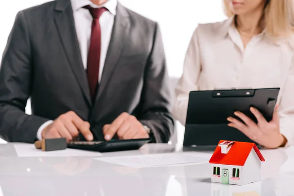 Foyer sélectif du modèle de maison avec les gens d'affaires isolés sur blanc, concept hypothécaire — Photo de stock