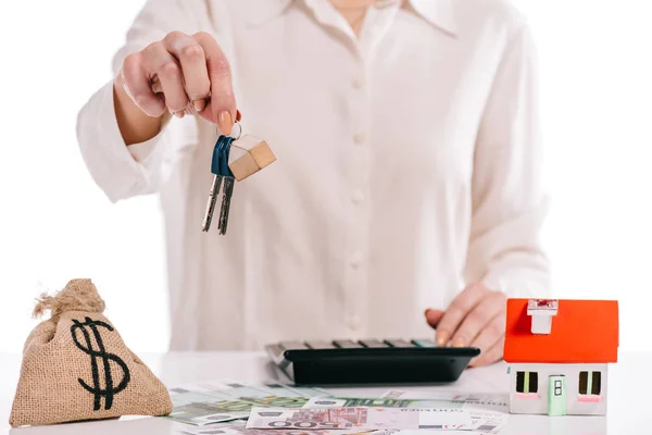 Cropped view of businesswoman holding keys near moneybag isolated on white, mortgage concept — Stock Photo