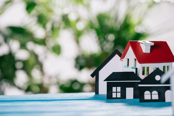 Selective focus of paper houses and house model on wooden desk, mortgage concept — Stock Photo