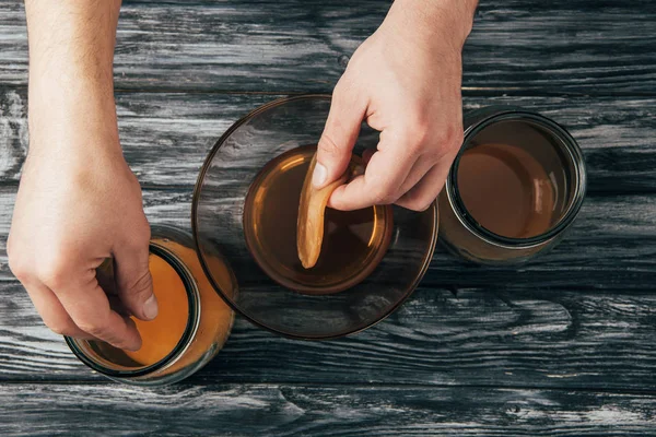 Von oben: Mann legt Kombucha-Pilze in Gläser — Stockfoto