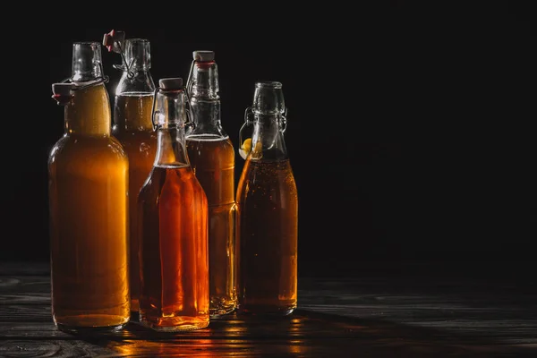 Homemade organic tea in glass bottles isolated on black — Stock Photo