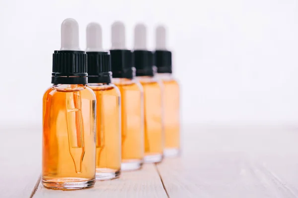 Selective focus of cbd oil in bottles with droppers on wooden surface isolated on white — Stock Photo