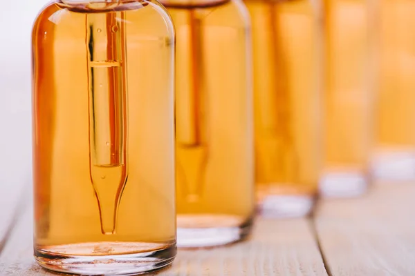 Mise au point sélective de l'huile de cbd dans des bouteilles avec compte-gouttes sur une surface en bois isolée sur blanc — Photo de stock