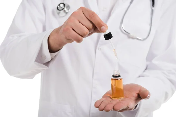 Cropped view of male doctor opening up bottle with cbd oil and dropper isolated on white — Stock Photo