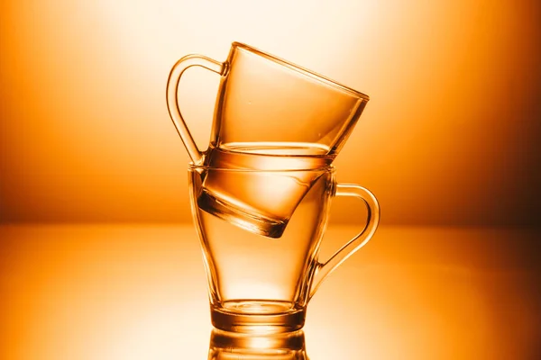 Selektiver Fokus von zwei Tassen Tee auf orangefarbenem Hintergrund — Stockfoto