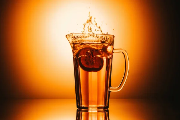 Selective focus of jar with tea and lemon slice on orange background — Stock Photo