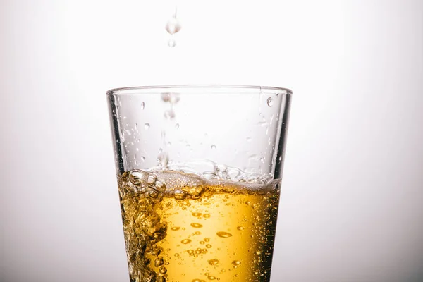 Primer plano de vaso de té y salpicaduras sobre fondo blanco - foto de stock