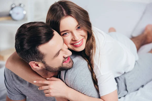 Selective focus of loving couple hugging and smiling in bed — Stock Photo