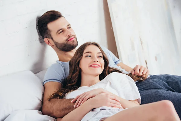 Взрослый любящий мужчина нежно обнимает женщину в постели — стоковое фото