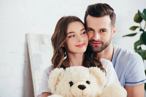 Foco seletivo de casal feliz abraçando ursinho de pelúcia — Fotografia de Stock