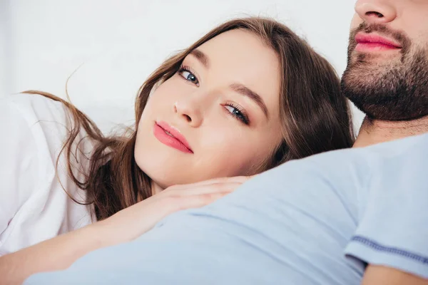 Young loving woman gentle embracing man in bed — Stock Photo