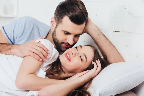 Adult loving man gentle looking at woman in bed — Stock Photo