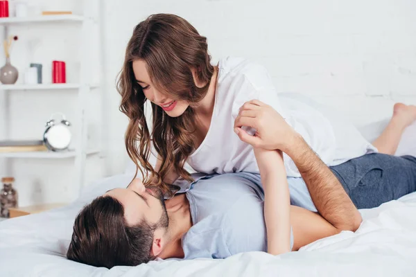 Foyer sélectif de jeune couple aimant embrasser doucement au lit — Photo de stock