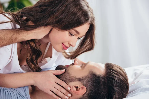 Selective focus of young loving couple gentle looking into eyes and embracing in bed — Stock Photo