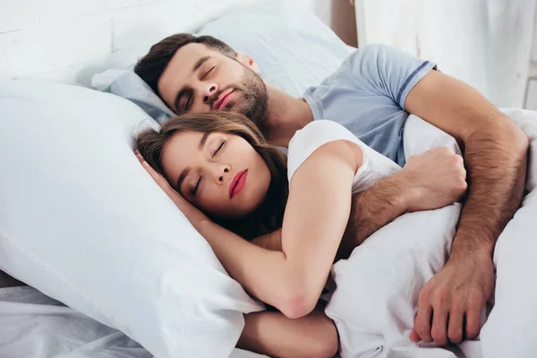 Casal adulto dormindo em cama branca macia no quarto — Fotografia de Stock