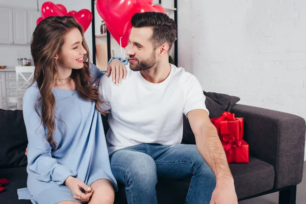 Feliz pareja celebrando el día de San Valentín mientras que la joven mujer abrazando al hombre - foto de stock