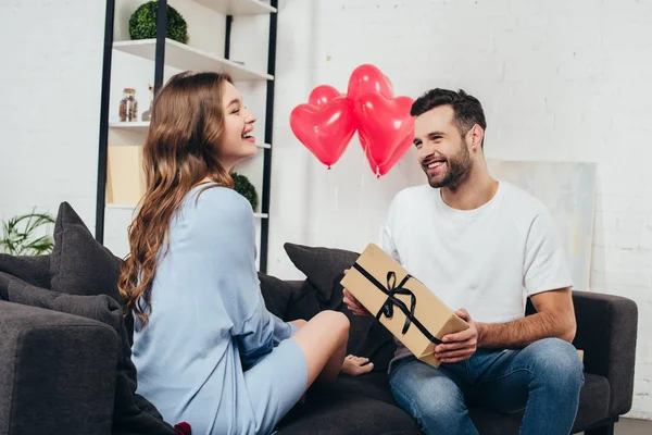 Joven hombre presentando caja de regalo a la novia en el día de San Valentín — Stock Photo