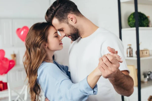 Selective focus of happy smiling couple dancing at home with st valentine day decoration — Stock Photo