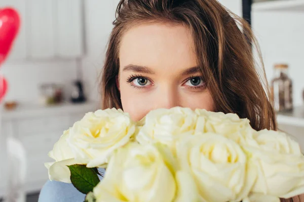 Foco seletivo de uma jovem menina bonita com rosto obscuro e rosas olhando para a câmera — Fotografia de Stock