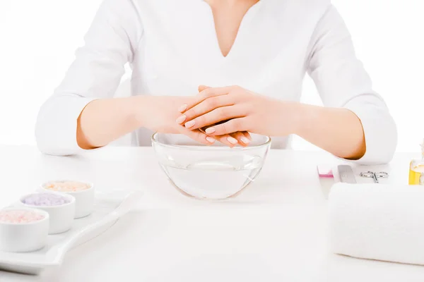 Vista ritagliata di manicure in uniforme facendo trattamento della mano isolato su bianco — Foto stock