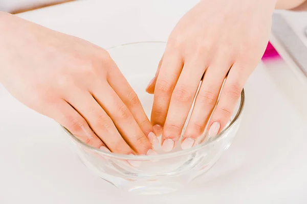 Vista parcial de la manicura con hermosos dedos tomando baño de uñas - foto de stock