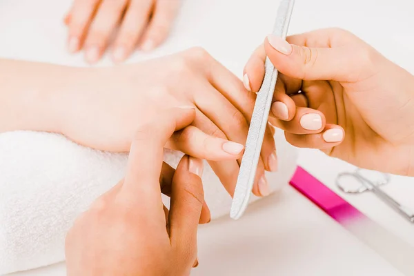 Cropped view of manicurist with perfect manicure filing nails — Stock Photo