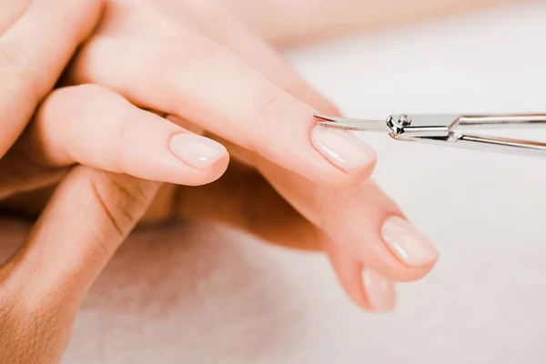 Vista ritagliata della manicure con forbici manicure per rimuovere la cuticola — Foto stock