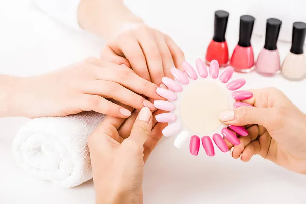 Partial view of manicurist holding pink nail polish palette — Stock Photo