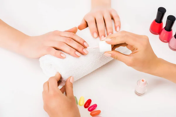 Cropped view of manicurist using nail polish and nail palette — Stock Photo