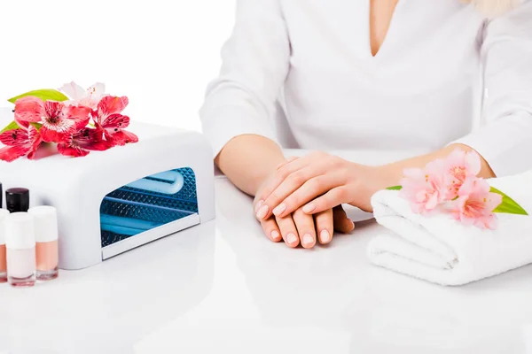 Foto parcial de manicurista con toalla y esmalte de uñas aislado en blanco - foto de stock