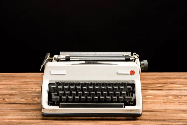 Machine à écrire vintage sur table en bois isolé sur noir — Photo de stock