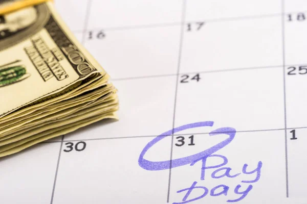 Selective focus of dollar banknotes, calendar with marked number 31 and 'pay day' lettering — Stock Photo