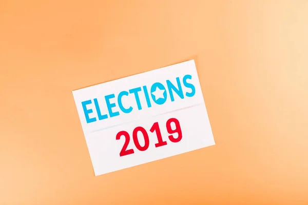 Top view of card with 'elections 2019' lettering isolated on orange — Stock Photo