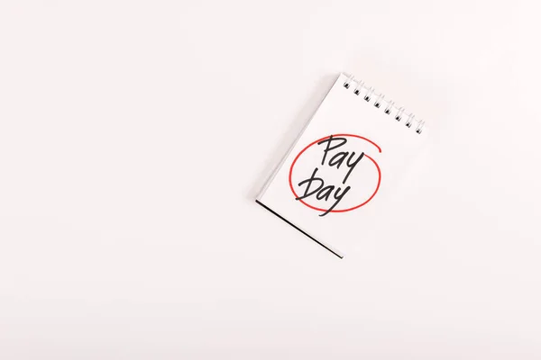 Top view of notebook with 'pay day' lettering isolated on white — Stock Photo