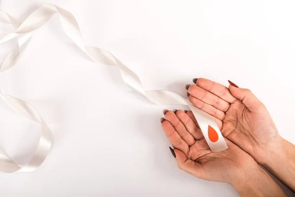 Abgeschnittene Ansicht einer Frau, die ein Band mit Bluttropfen in der Hand hält, Diabetes-Bewusstsein — Stockfoto